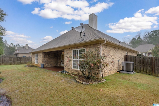 rear view of property featuring a yard, a patio, and central AC unit