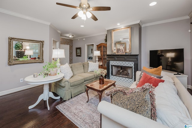 living room featuring a tile fireplace, wood-type flooring, ceiling fan, and ornamental molding