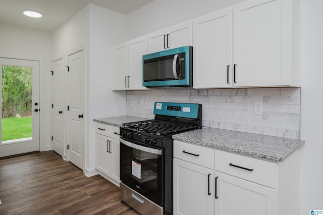 kitchen with white cabinets, light stone countertops, and stainless steel appliances