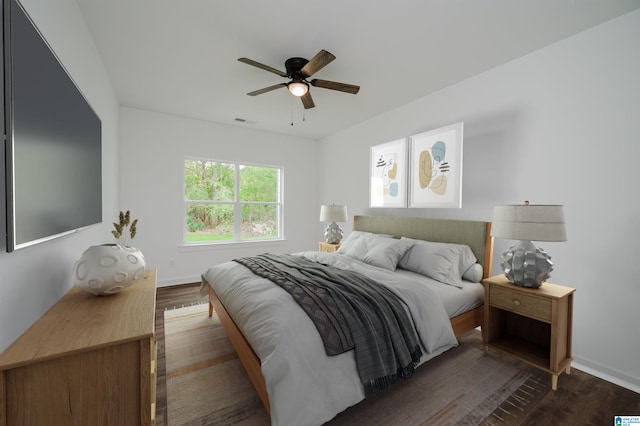bedroom with dark wood-style flooring, visible vents, baseboards, and ceiling fan