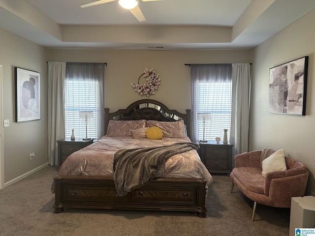 bedroom with carpet, a tray ceiling, and ceiling fan