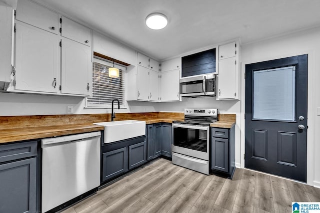 kitchen featuring wooden counters, appliances with stainless steel finishes, sink, white cabinets, and gray cabinets