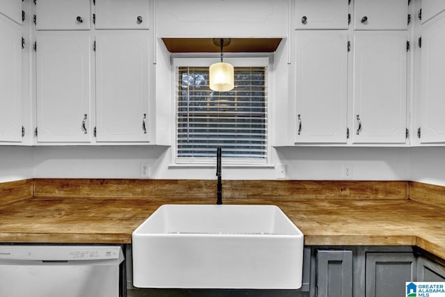 kitchen with sink, wooden counters, stainless steel dishwasher, pendant lighting, and white cabinets