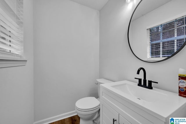 bathroom with hardwood / wood-style flooring, vanity, and toilet