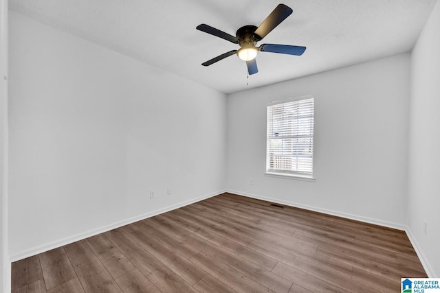 spare room with ceiling fan and wood-type flooring