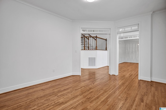 spare room featuring light hardwood / wood-style floors and ornamental molding