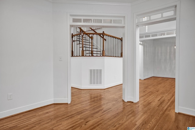 interior space with crown molding and light hardwood / wood-style flooring