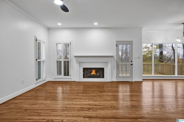 unfurnished living room with ceiling fan, hardwood / wood-style floors, and crown molding