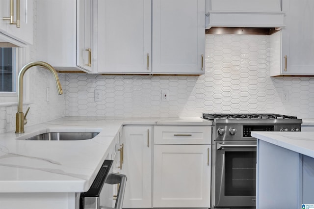 kitchen with white cabinetry, stainless steel range, sink, tasteful backsplash, and light stone counters