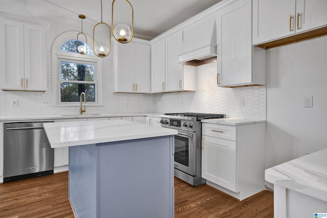 kitchen with white cabinets, appliances with stainless steel finishes, and light stone countertops