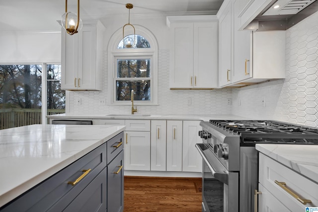 kitchen with white cabinets, stainless steel stove, premium range hood, and sink