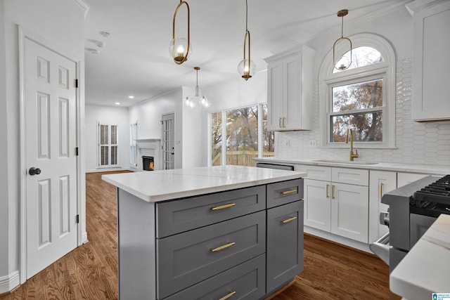 kitchen with plenty of natural light, a center island, pendant lighting, and sink