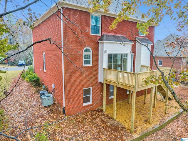 rear view of property with a wooden deck and central AC unit