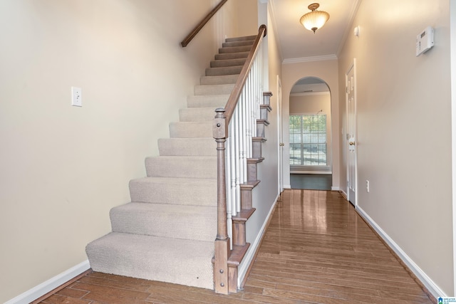 staircase featuring crown molding and hardwood / wood-style floors