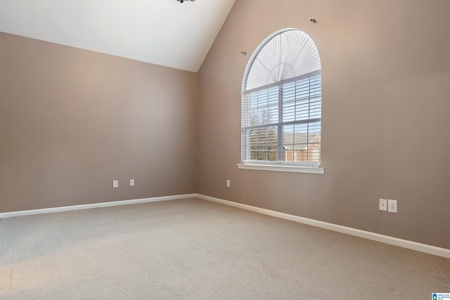 carpeted spare room featuring vaulted ceiling