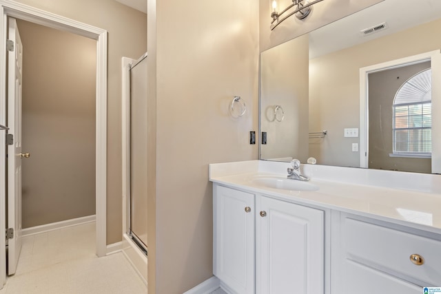 bathroom featuring vanity and a shower with shower door