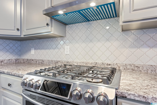 kitchen featuring decorative backsplash, stainless steel range oven, and exhaust hood