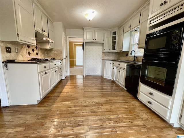 kitchen featuring black appliances, white cabinets, sink, a textured ceiling, and light hardwood / wood-style floors