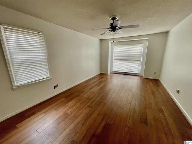 empty room with ceiling fan, a textured ceiling, and hardwood / wood-style flooring