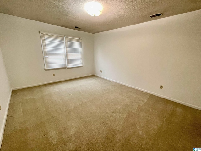 unfurnished room featuring carpet and a textured ceiling