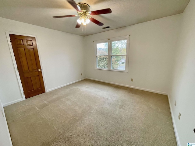 carpeted spare room featuring a textured ceiling and ceiling fan