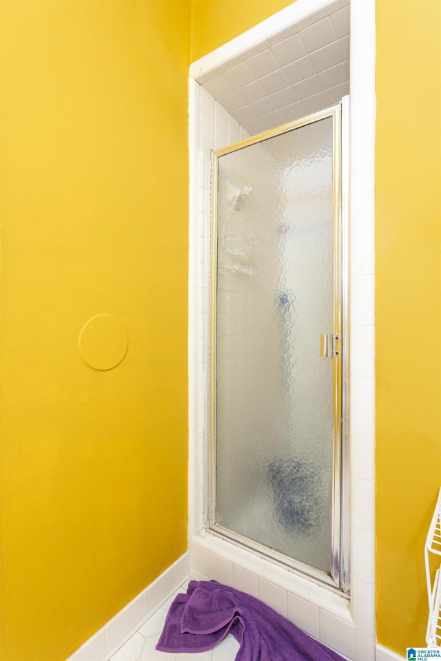 bathroom with tile patterned flooring and walk in shower