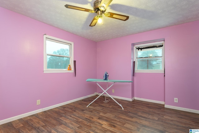 unfurnished room featuring a textured ceiling, ceiling fan, and dark hardwood / wood-style floors