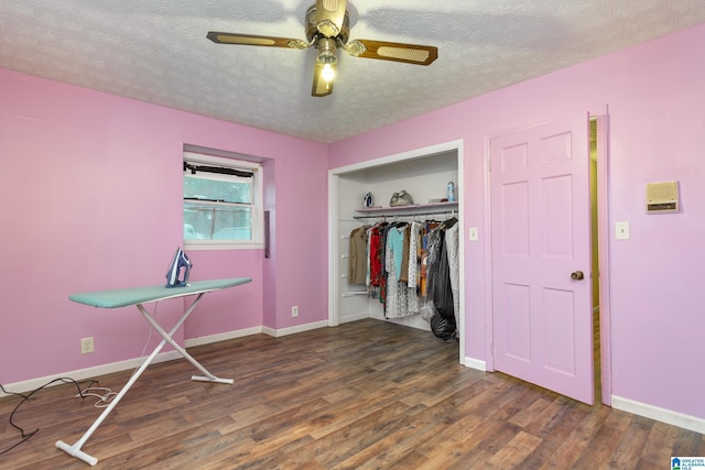 unfurnished bedroom with a textured ceiling, a closet, dark hardwood / wood-style floors, and ceiling fan