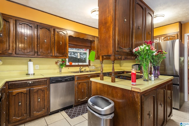 kitchen with sink, stainless steel dishwasher, black electric cooktop, a textured ceiling, and light tile patterned flooring