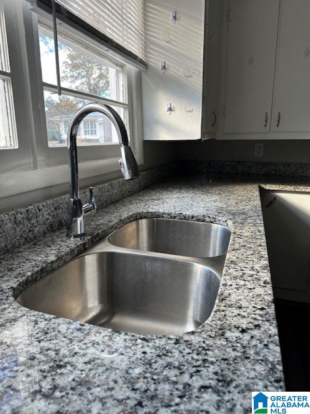 interior details featuring sink and stone countertops