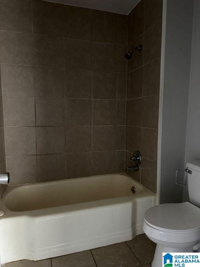 bathroom with tile patterned flooring, tiled shower / bath combo, and toilet