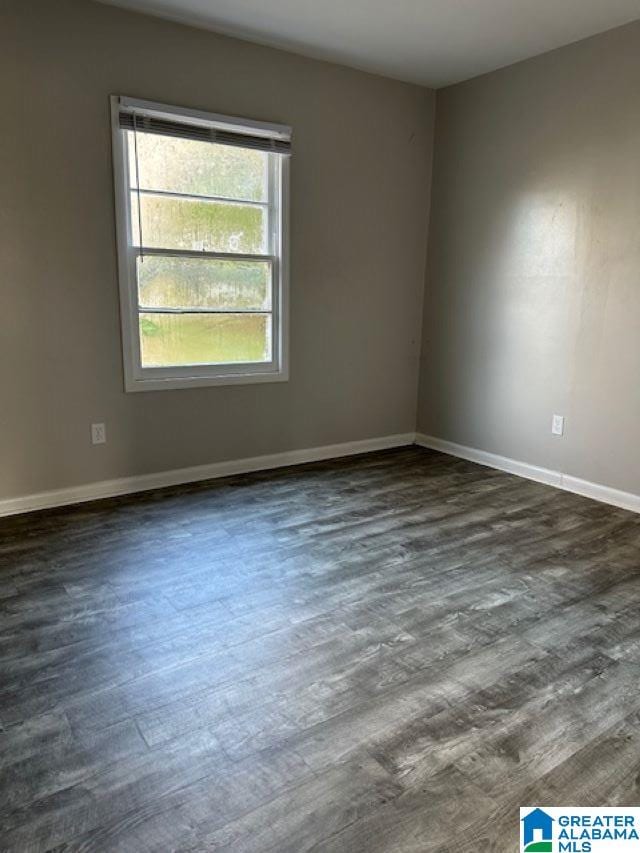 unfurnished room with dark hardwood / wood-style flooring