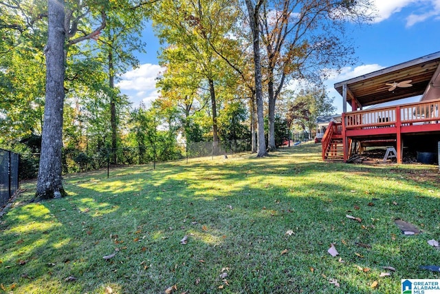 view of yard featuring ceiling fan and a deck