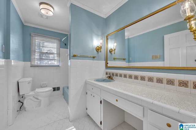 full bathroom with tile patterned floors, toilet, vanity, tile walls, and ornamental molding