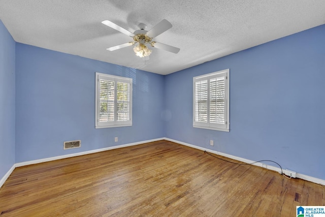 spare room featuring ceiling fan, light hardwood / wood-style floors, and a textured ceiling