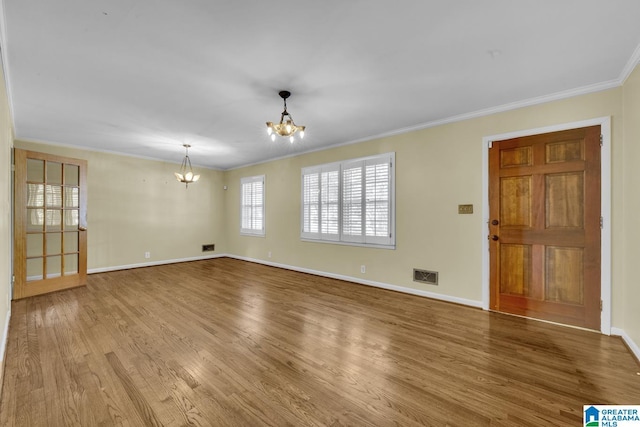 interior space with hardwood / wood-style flooring, an inviting chandelier, and crown molding