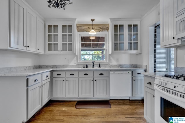 kitchen with white cabinets, light wood-type flooring, white appliances, and decorative light fixtures