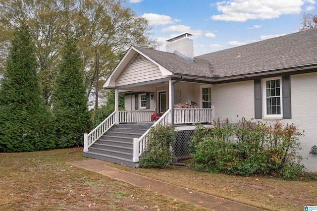 view of front of property with covered porch and a front lawn