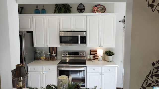 kitchen featuring white cabinets, decorative backsplash, and appliances with stainless steel finishes