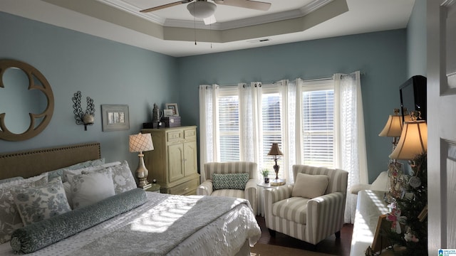 bedroom with ceiling fan, a raised ceiling, and ornamental molding