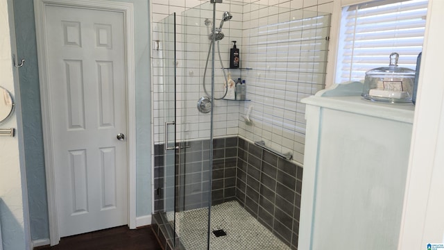 bathroom with a shower with shower door and hardwood / wood-style flooring