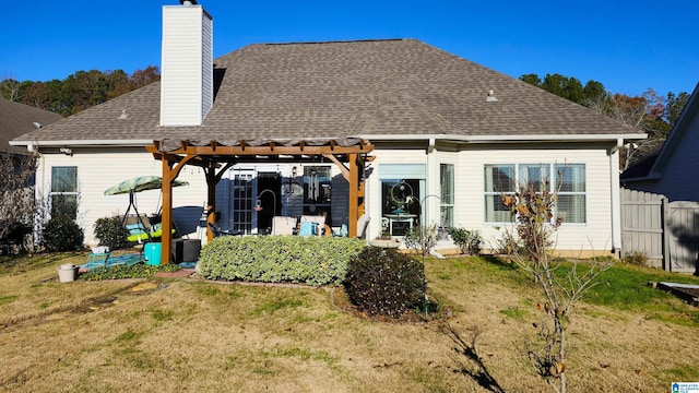 rear view of property featuring a pergola and a yard