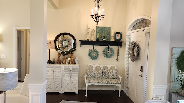 sitting room with a towering ceiling and an inviting chandelier