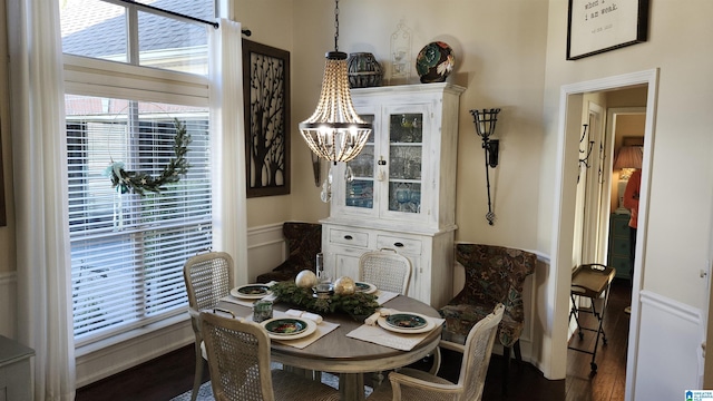 dining area with hardwood / wood-style floors and a notable chandelier