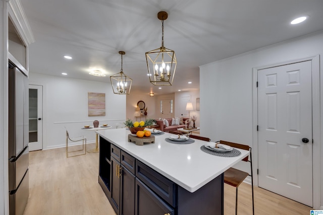 kitchen featuring decorative light fixtures, a kitchen island, light hardwood / wood-style floors, and a breakfast bar area