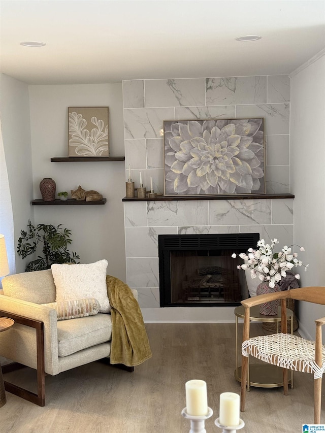 living room with hardwood / wood-style floors and a tiled fireplace