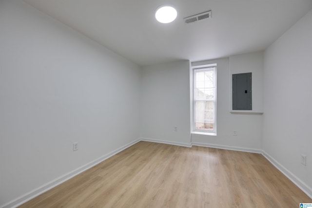 unfurnished room with light wood-type flooring and electric panel