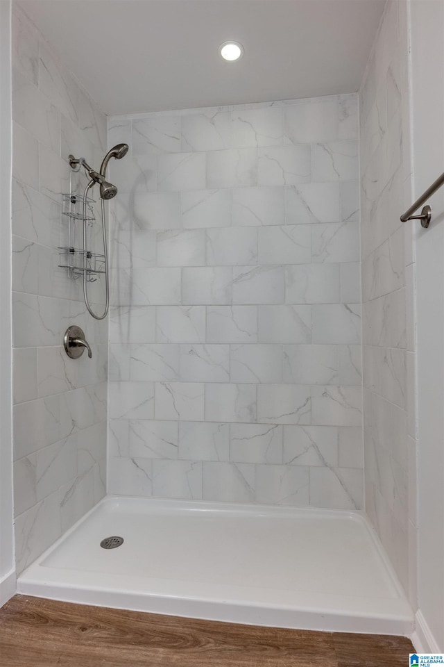 bathroom featuring hardwood / wood-style floors and a tile shower