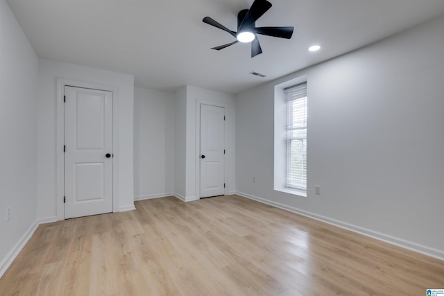 empty room with ceiling fan and light hardwood / wood-style floors