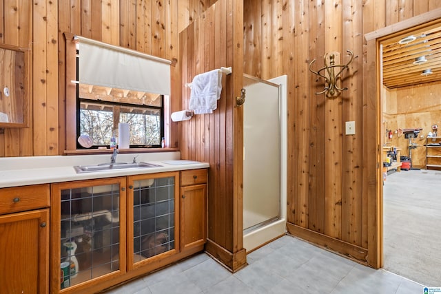 kitchen featuring sink, light colored carpet, and wood walls